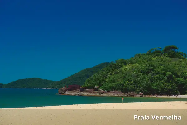Praias em Sao Paulo - Praia Vermelha, em Ubatuba, com areia clara, mar calmo e morros verdes ao fundo.